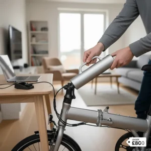 A person removing the portable battery from a folding electric bike for convenient indoor charging in a British flat.