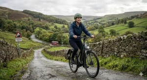 A cyclist effortlessly riding a 36v electric bike up a steep 20 percent gradient hill in the British countryside.