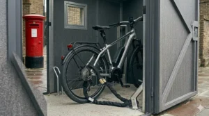 A high-end electric bike secured to a heavy-duty ground anchor inside a professional UK cycle storage unit.