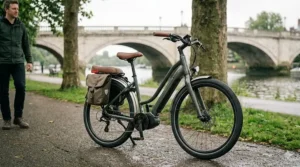 Alt text for image 8: A fully equipped electric hybrid bike with full-length mudguards and integrated lights, parked on a damp UK riverside path, ideal for comfortable year-round commuting.