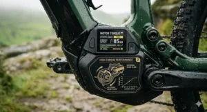 Alt text for a technical illustration of an integrated e-bike garage charging system showing a UK 3-pin plug connection and battery charging status.