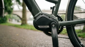 Alt text for image 9: A close-up of a mid-drive motor on a dark green electric bike, designed to provide smooth and natural power assistance on steep British hills for a more comfortable ride.