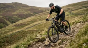 An electric enduro bike navigating a technical descent in the UK hills.