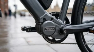 Close-up detail of a 250W mid-drive electric bike motor, with clear labelling indicating UK legal compliance, mounted on a charcoal frame in a London environment.