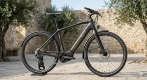 A modern carbon fibre ebike charging from a standard UK home wall socket.