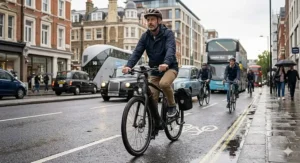 A cyclist commuting through busy city traffic on a black carbon fibre ebike.