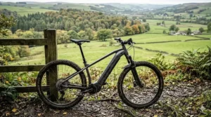 An electric XC bike parked on a gravel path overlooking a rolling UK landscape.