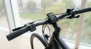 Handlebar display and control unit showing battery level and assist modes on an electric commuter bike.