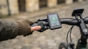 Close-up of an e-bike handlebar display showing the active walk mode icon.