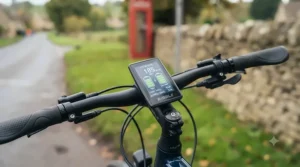 A close-up of an e-bike handlebar display showing an increased distance range estimate after installing a second battery.