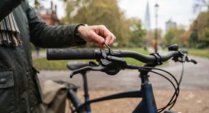 Hands adjusting the angle of hydraulic brake levers on electric bicycle handlebars to match wrist alignment.