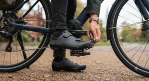 Detail view of cycling shoes and clipless pedals being adjusted for proper foot alignment on an electric commuter bicycle.