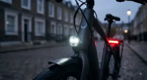 Integrated LED front and rear lights illuminating a lit electric commuter bike during a dark evening commute in the UK.