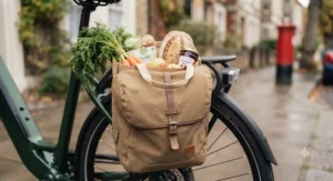 Waterproof pannier bags securely attached to the rear rack of an electric bike, filled with weekly groceries.