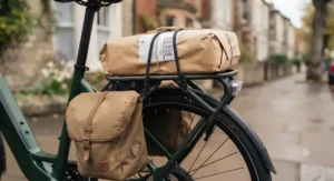 A heavy package strapped down with bungee cords onto the sturdy rear rack of a utility electric bike.