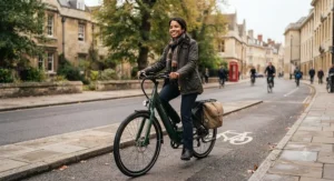A commuter wearing a hi-vis jacket riding an electric bike with a built-in rear rack through a British city cycle lane.