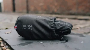 Detailed close-up of the drawstring storage pouch for the AURA CYCLING weatherproof saddle cover, beaded with rainwater.