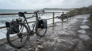 An electric bike for gritted winter roads navigating a damp coastal path covered in salt residue.